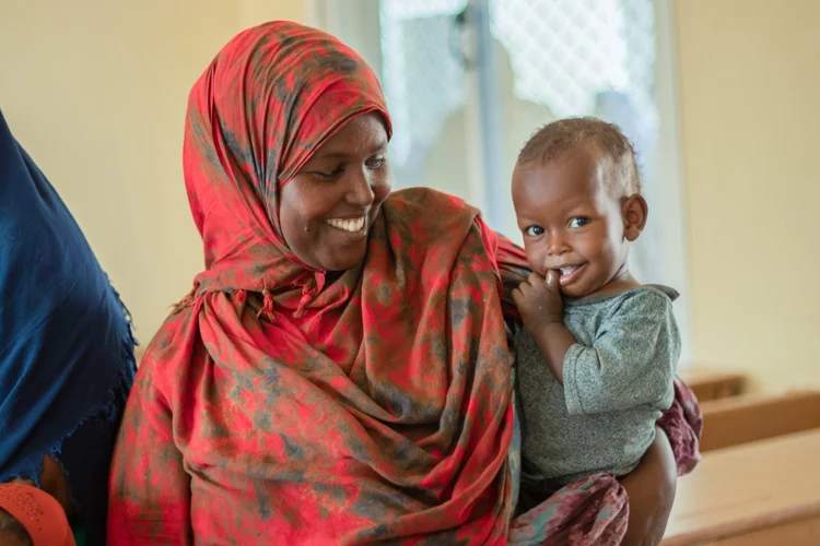 A mother smiling with her newborn baby